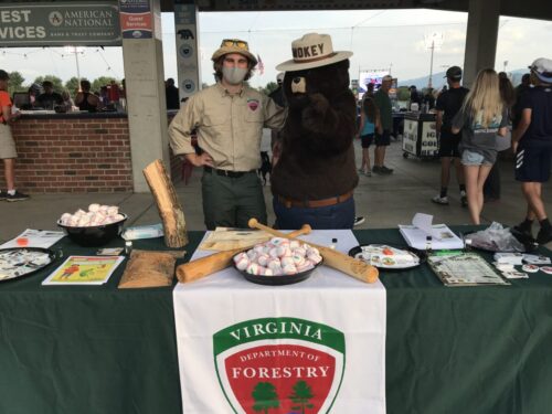 Teagan O’Brien (DOF forest health technician) and Smokey hand out EAB information at the Salem Red Sox baseball stadium.